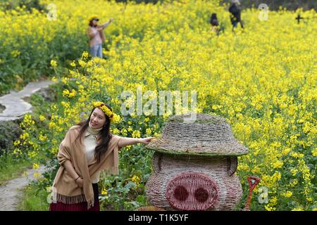 Nanchang, China's Jiangxi Province. 25 Mär, 2019. Touristen genießen, sich inmitten der Cole Blume Felder in der landschaftlich reizvollen Gegend von Jiangling Wuyuan County, im Osten der chinesischen Provinz Jiangxi, 25. März 2019. Credit: Peng Zhaozhi/Xinhua/Alamy leben Nachrichten Stockfoto