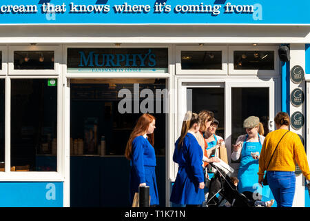 Mitarbeiter von Murphy's Ice Cream Shop bieten Passanten in Killarney, County Kerry, Irland, kostenlose Eiscremeproben an Stockfoto