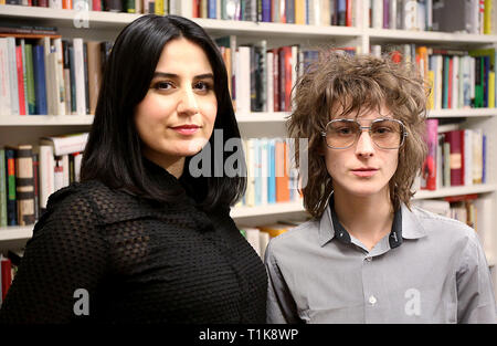 27. März 2019, Nordrhein-Westfalen, Köln: Karosh Taha (l) und Josefine Rieks, Autoren und Gewinner des NRW-Preis für Literatur, etwa bei der lit.Cologne vor einem Bücherregal zu lesen. Foto: Oliver Berg/dpa Stockfoto
