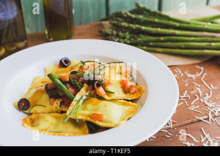 Ravioli mit Oliven, Spargel und Tomaten Stockfoto