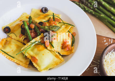 Ravioli mit Oliven, Spargel und Tomaten Nahaufnahme Stockfoto