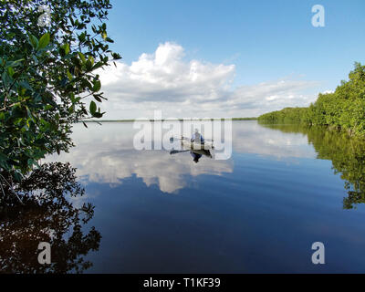 Der Everglades National Park, Florida 02-05-2017 Active Senior Kajaks auf eine außergewöhnlich ruhig Blässhuhn Bucht inmitten einer markanten cloud Reflexionen. Stockfoto