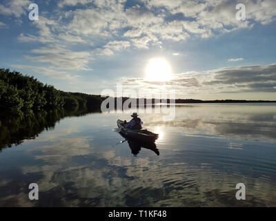 Der Everglades National Park, Florida 02-05-2017 Active Senior Kajaks auf eine außergewöhnlich ruhig Blässhuhn Bucht inmitten einer markanten cloud Reflexionen. Stockfoto