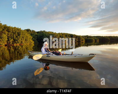 Der Everglades National Park, Florida 02-05-2017 Active Senior Kajaks auf eine außergewöhnlich ruhig Blässhuhn Bucht inmitten einer markanten cloud Reflexionen. Stockfoto