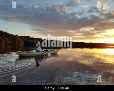 Der Everglades National Park, Florida 02-05-2017 Active Senior Kajaks auf eine außergewöhnlich ruhig Blässhuhn Bucht inmitten einer markanten cloud Reflexionen. Stockfoto