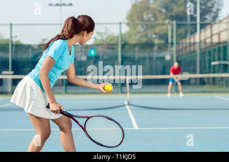 Professionelle weibliche Spieler lächelnd während Tennis Match serviert Stockfoto