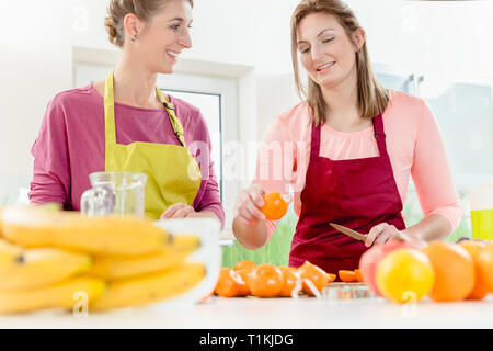Frau auf der Suche nach ihrem Freund schneiden Orangen Stockfoto