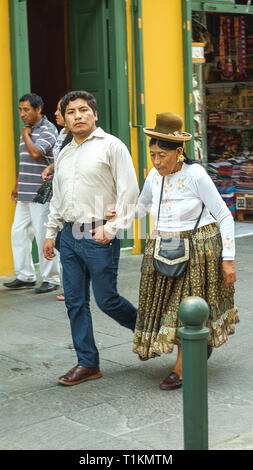 Lima, Peru - 27.12.2018. Paar Mann und die alte Frau, die Menschen in modernen und traditionellen Kleidung auf der Straße von Lima, der Hauptstadt Perus, Lateinamerika. Stockfoto