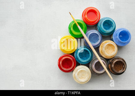 Bunte Glasfenster oder Öl, Acryl Farben mit Pinsel auf grauem Hintergrund mit Kopie Raum, Ansicht von oben. Stockfoto