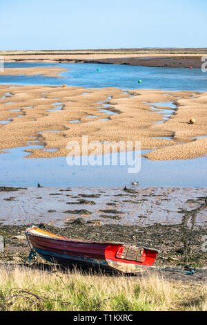 Bunte Boote marooned auf Sandbänken bei Ebbe im Osten Flotte Mündung an der Brunnen neben dem Meer, North Norfolk Coast, East Anglia, England, UK. Stockfoto