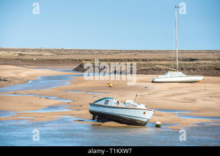 Bunte Boote marooned auf Sandbänken bei Ebbe im Osten Flotte Mündung an der Brunnen neben dem Meer, North Norfolk Coast, East Anglia, England, UK. Stockfoto