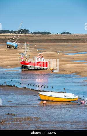 Bunte Boote marooned auf Sandbänken bei Ebbe im Osten Flotte Mündung an der Brunnen neben dem Meer, North Norfolk Coast, East Anglia, England, UK. Stockfoto