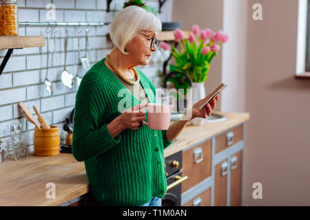 Profil Schuß von gealterten Dame suchen Bei Bilderrahmen Stockfoto