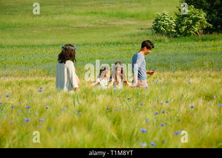 Familienspaziergängen in sonniger, idyllischer ländlicher Grünfläche mit Wildblumen Stockfoto