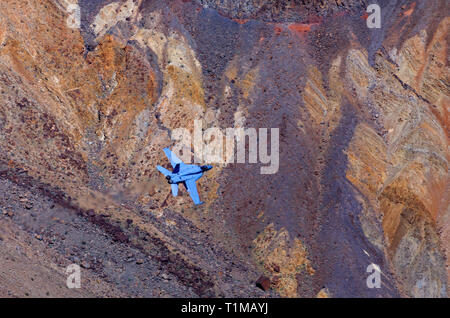 In diesem Schoß eine Boeing F/A-18E Super Hornet macht einen heruntergekommenen Rainbow/Star Wars Canyon im Death Valley National Park, Kalifornien, USA. Stockfoto