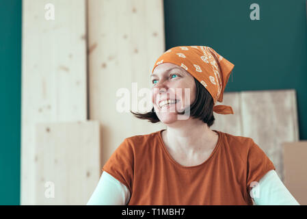 Portrait von Lächeln glücklich Frau Carpenter tragen Kopftuch bandana in kleinen Unternehmen Holzarbeiten workshop Stockfoto
