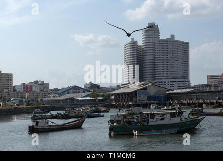 Alte Fischerboote in der Nähe von Fischmarkt in Panama City mit Skyline im Hintergrund Stockfoto