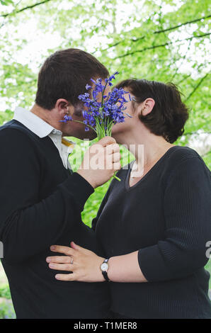 Mann küsst Freundin auf ein romantisches Date im Freien. Stockfoto