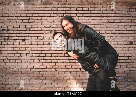 Paar im Huckepack mit einer guten Zeit von lachen und lieben ihre bevorstehende Hochzeit zu feiern. Stockfoto