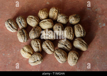 Getrocknete Walnüsse (Juglans) in ihren Schalen. Es enthält eine Menge Mangan, Magnesium, Phosphor und Vitamin B6. Walnüsse enthält auch andere Mineralien und Stockfoto