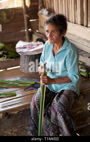 Indigene Völker der Alfur Nuaulu Gruppe Zusammenfügen von Palmblättern, Seram Insel, Molukken, Indonesien Stockfoto