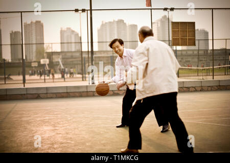 Mitte der erwachsene Mann spielen Basketball mit einem erwachsenen Mann. Stockfoto