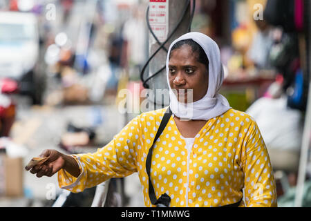 Port Louis, Mauritius - Januar 30, 2019: Eine islamische Frau, tragen, hijab Geld geben, Handel, im Freien auf dem Markt in Port Louis, Mauritius. Stockfoto