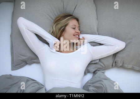 Süße blonde Frau, die selbst am Morgen erstreckt sich Stockfoto