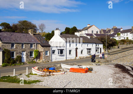 Blick auf die Häuschen am Wasser mit Fischerbooten am Strand im Dorf Moelfre, Isle of Anglesey, Wales, Großbritannien, Großbritannien Stockfoto