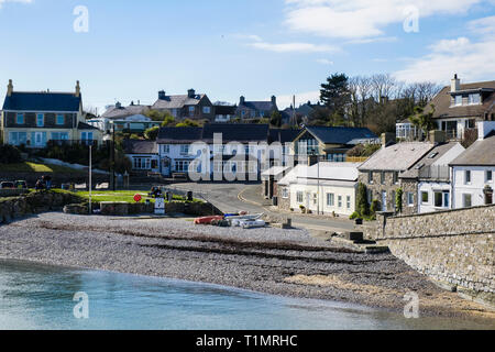 Blick über Strand Cottages und Pub auf Wasser im Dorf Moelfre, Isle of Anglesey, Wales, Großbritannien, Großbritannien Stockfoto