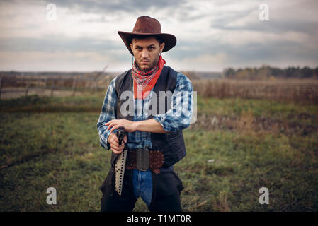 Brutale Cowboy mit Revolver, Schießerei auf der Ranch Stockfoto