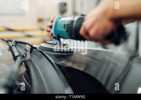 Männliche Person mit Poliermaschine reinigt Auto Stockfotografie
