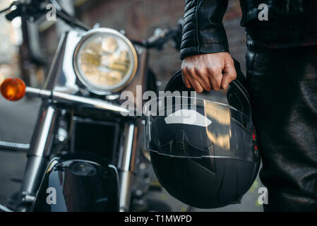 Biker in Lederjacke mit Helm in der Hand Stockfoto