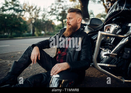 Biker entspannen nach einer Straßenfahrt auf seinem Häcksler Stockfoto