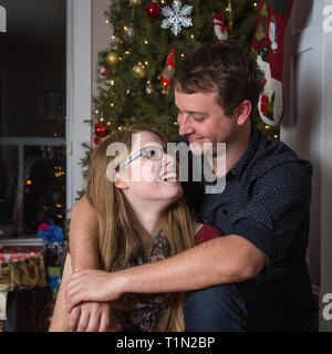 Junges Paar in Liebe vor Weihnachtsbaum Stockfoto
