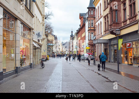 Main Street mit verschiedenen Geschäften in alten Gebäuden und nur wenige Leute im historischen Stadtzentrum an einem regnerischen Tag in Heidelberg, Deutschland Stockfoto