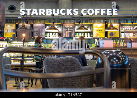 Lyon, Frankreich - 16. März 2019: die Leute bestellen Kaffee und Kekse bei Starbucks in Lyon Saint Exupery Flughafen, während der Wartezeit in - zwische Stockfoto