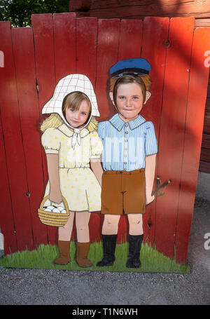 Zwei Mädchen Gesichter in einem Gesicht loch Board mit einem gemalten Bild der altmodische Junge und Mädchen. Stockfoto