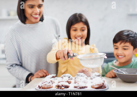 Mutter und Kinder backen Muffins in der Küche Stockfoto