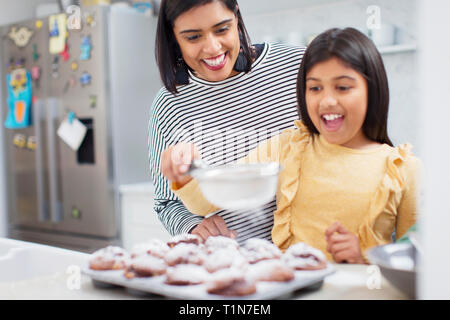 Mutter und Tochter backen Muffins in der Küche Stockfoto