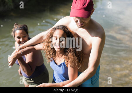 Glückliche Familie spielen im Fluss Stockfoto