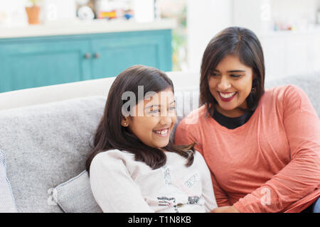 Glückliche Mutter und Tochter auf dem Sofa Stockfoto