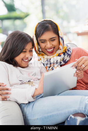 Lachen, glücklich, Mutter im hijab und Verwendung digitaler tablet Tochter Stockfoto