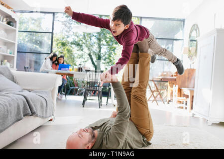Vater und Sohn spielen auf Wohnzimmer Erdgeschoss Stockfoto