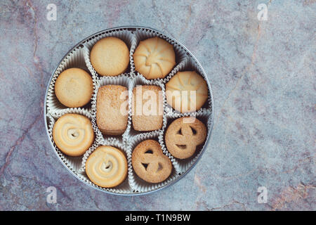 Cookies in einer Metalldose auf einem Marmor Hintergrund Stockfoto