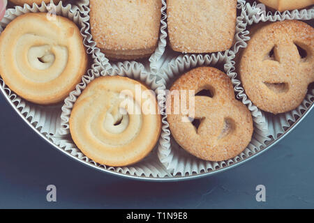 Cookies in einer Metalldose auf einem dunkelblauen Hintergrund. Close-up. Makro Stockfoto