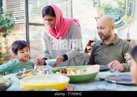 Mutter in der Hijab, das Abendessen für die Familie am Tisch Stockfoto