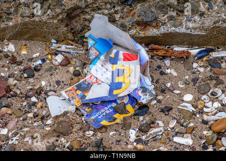 Irvine, Schottland, UK - 18. März 2019: Umwelt Bild von Abfällen mit etwas Pappe von McDonalds und Plastikmüll am Strand verworfen werden Stockfoto