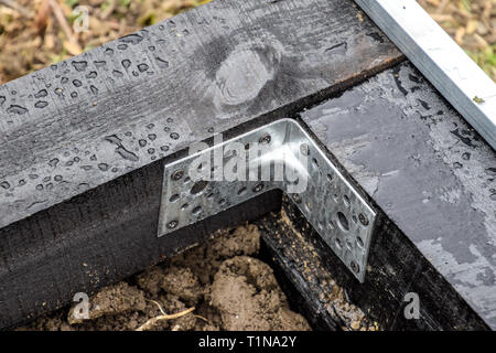 Installation von Polycarbonat Gewächshäuser. Gewächshaus für den heimischen Garten. Die Befestigung der Winkel der Gelenke einer Bar aus Holz im Gewächshaus. Stockfoto