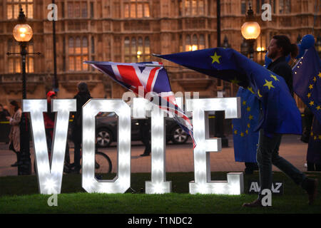 Anti-Brexit Demonstranten mit einem beleuchteten Schild 'Lasst uns Stimme" außerhalb des Houses of Parliament, London, an dem Tag, an dem die Abgeordneten aufgefordert werden, eine Reihe alternativer Brexit Optionen in Betracht zu ziehen, nachdem das Parlament die Kontrolle über den Commons Agenda zu einer Reihe von 'Probeabstimmungen 'force beschlagnahmt. Stockfoto